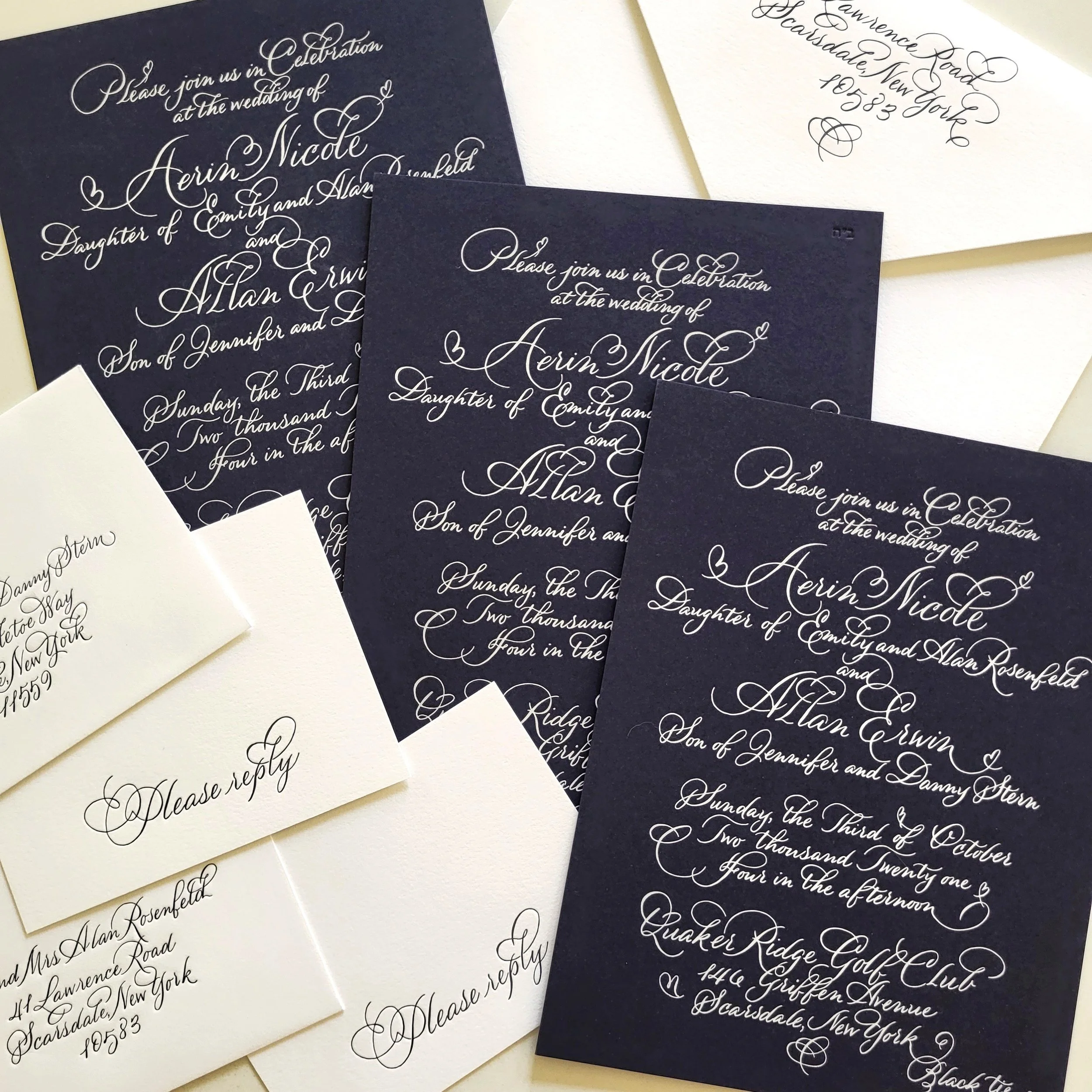 Close-up of elegant navy and white wedding invitations with ornate cursive text for the wedding of Erin Nicole and Alan Erwin, and corresponding address labels with similar calligraphy.