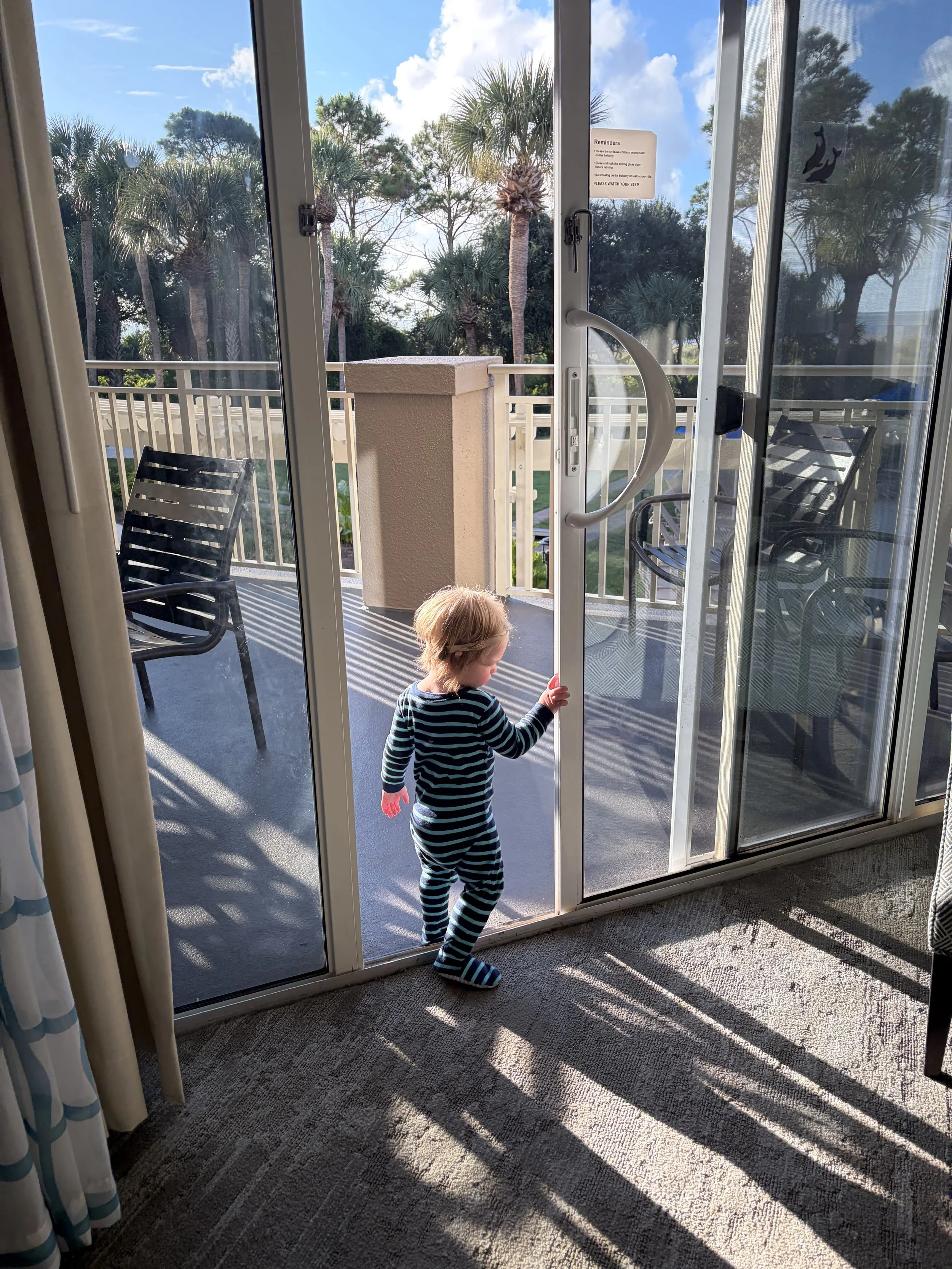Toddler entering and existing safe balcony overlooking the ocean and pool at the Marriott Grande Ocean on Hilton Head Island