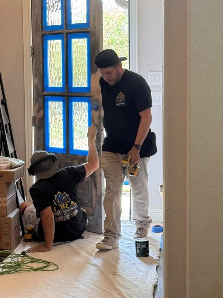 Lara Home & Commercial Services technicians working on a residential front door repair and installation.