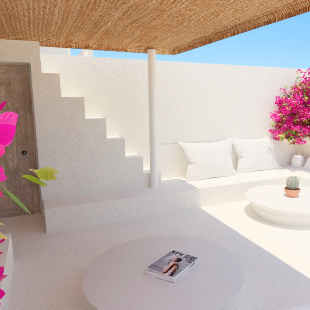 Espacio al aire libre con muebles blancos, cojines, una mesa redonda con revistas, plantas, flores rosadas y cielo azul, bajo una pergola de madera.