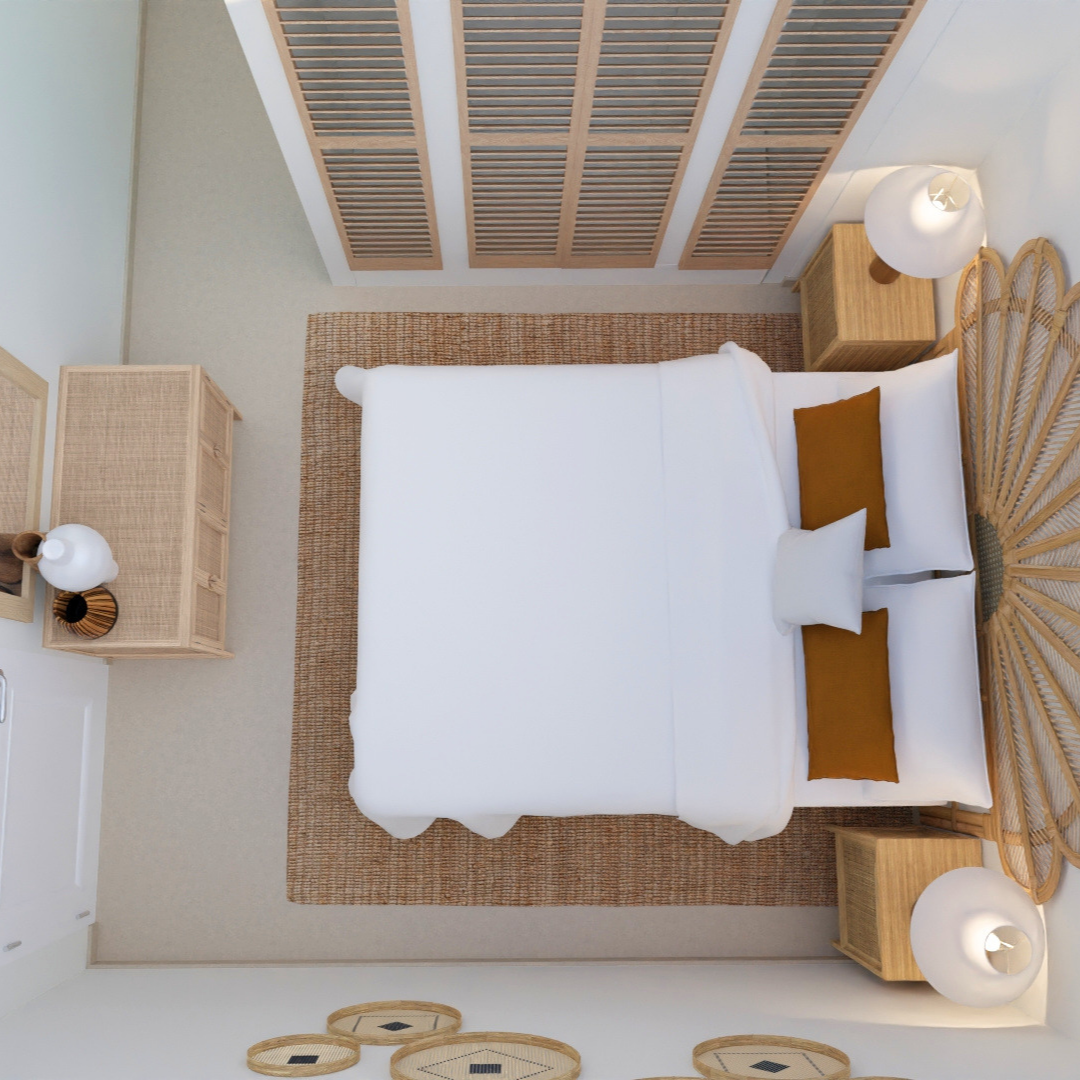 Vista aérea de una habitación moderna con cama blanca y cojines color ocre, mesas de noche de madera con lámparas, alfombra de yute y puerta de armario de listones de madera.