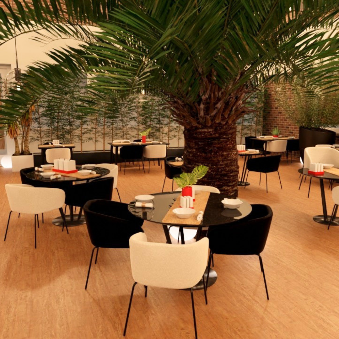 Un restaurante con mesas decoradas, un árbol grande en el centro, y plantas en las paredes.