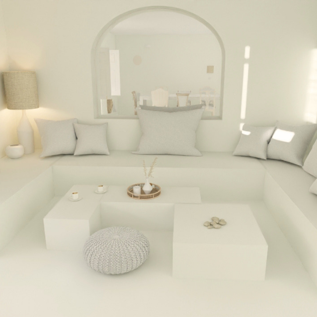 Sala de estar minimalista en tonos blancos y grises con cojines, lámpara y mesa decorativa.