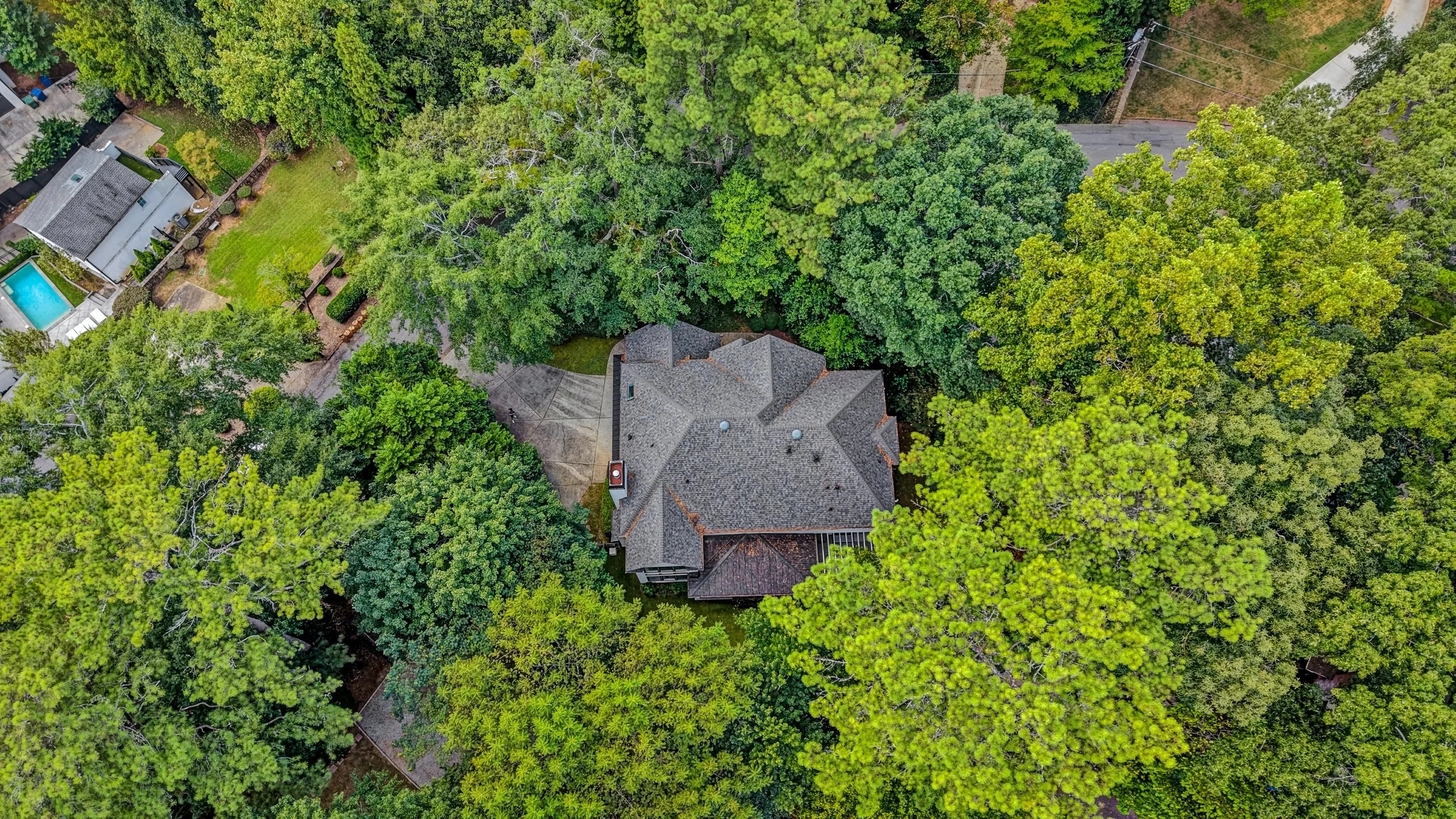 Aerial view of 70 Honour Circle NW surrounded by dense green trees in a residential neighborhood.