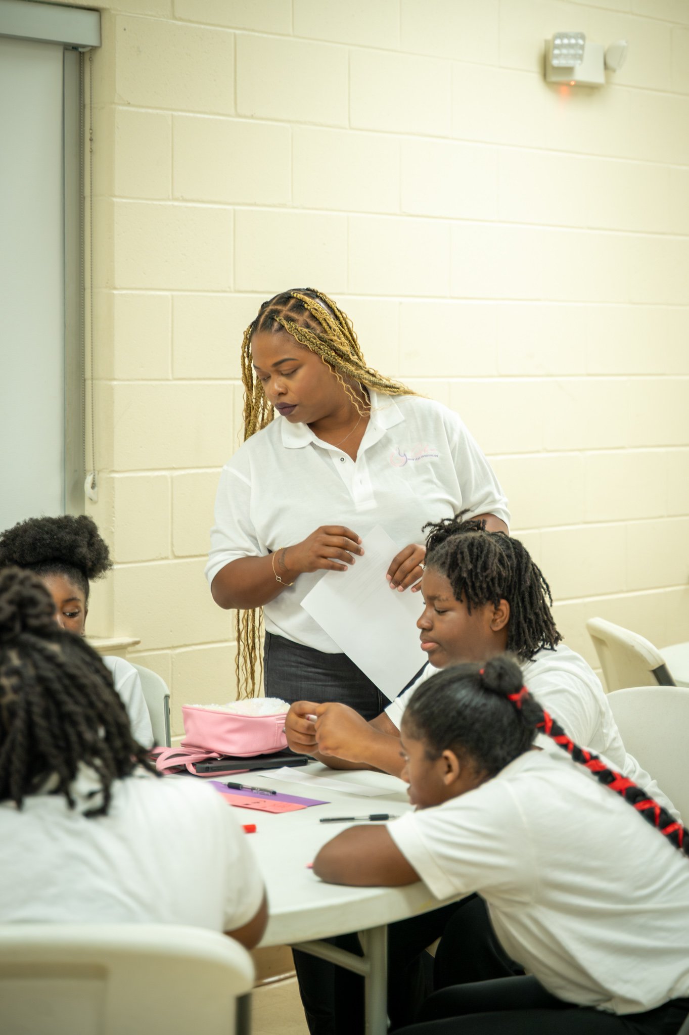 “A GLOW mentor guiding girls through a hands-on learning activity.”
