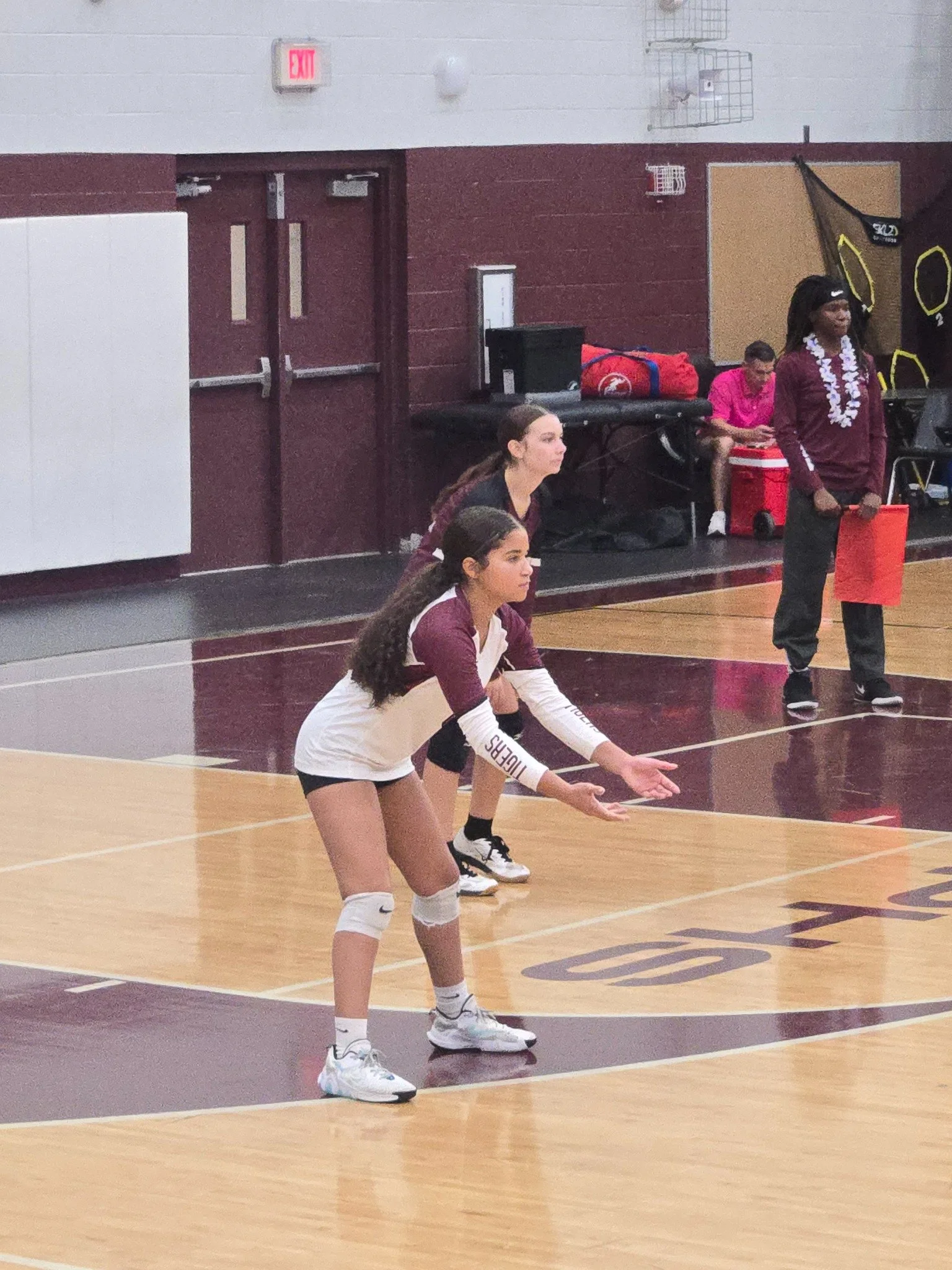 A volleyball player prepares to receive the ball during a game.