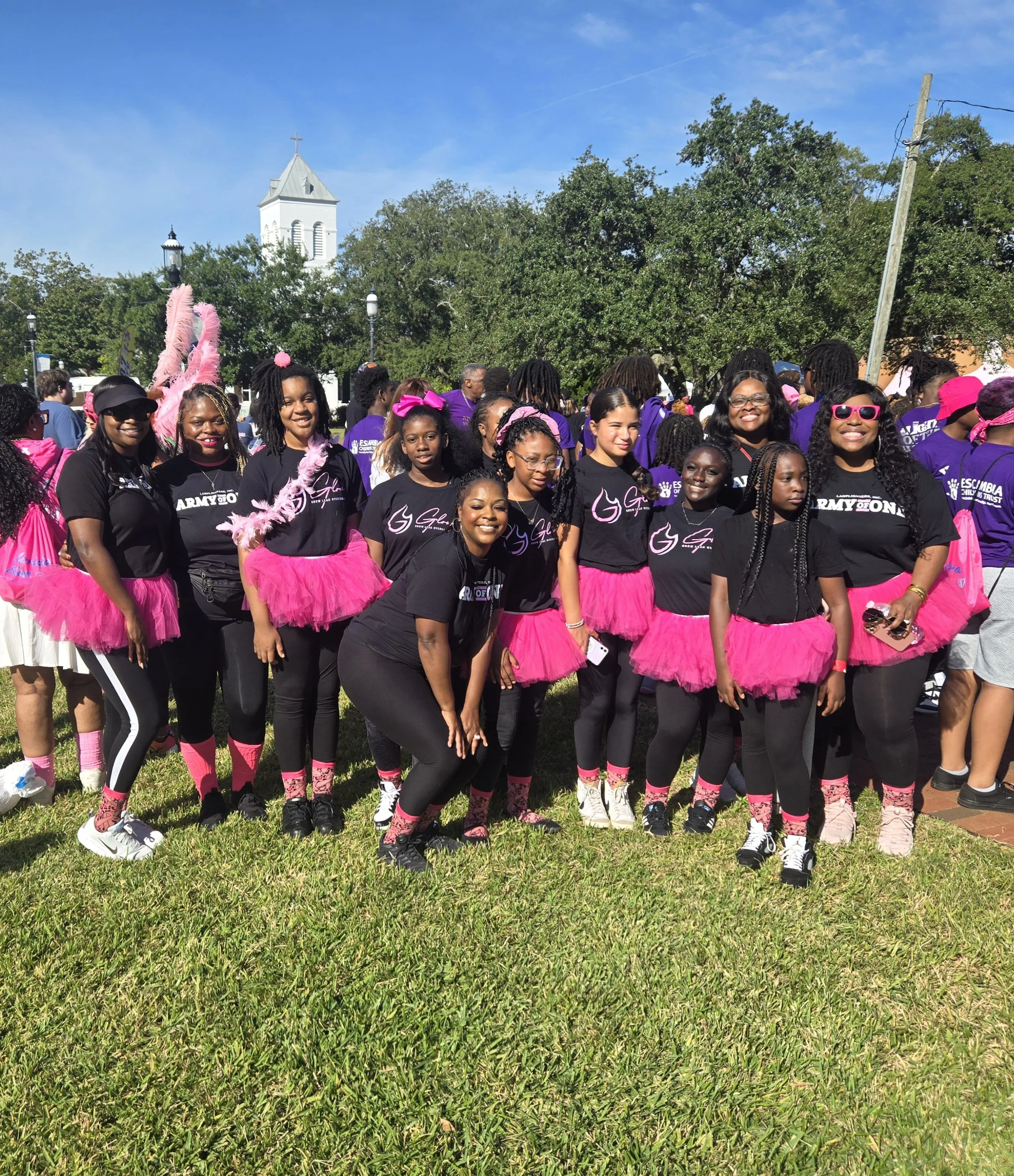 GLOW girls and mentors participating in an outdoor community event in Pensacola giving back and supporting the breast cancer fight.