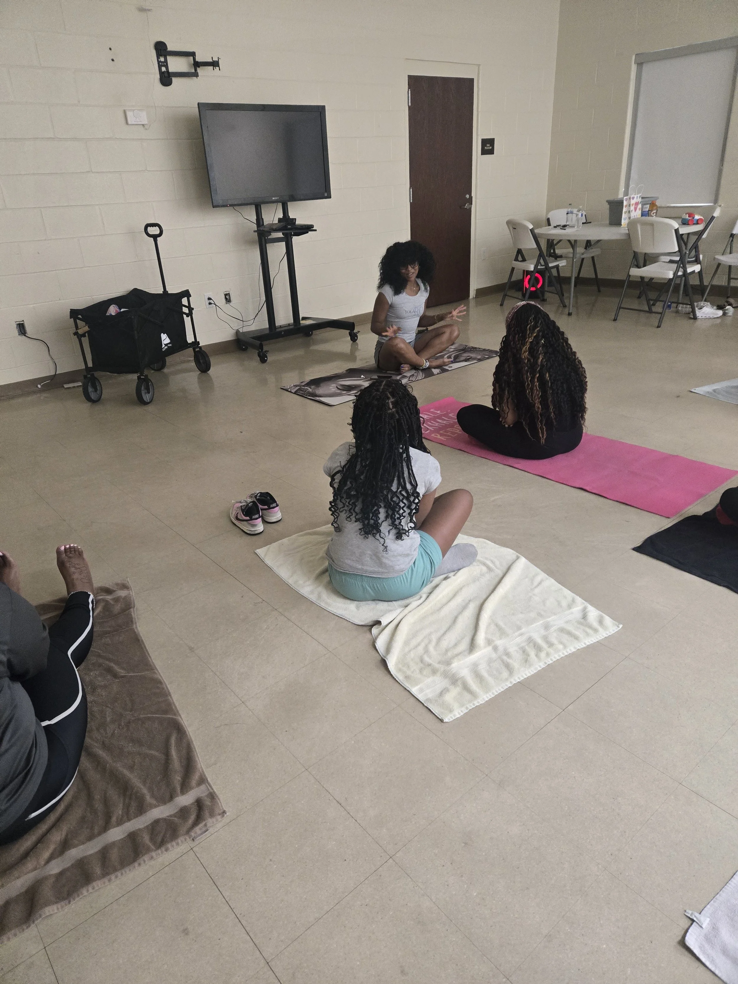 A wellness instructor leading GLOW girls through a yoga and mindfulness activity.”