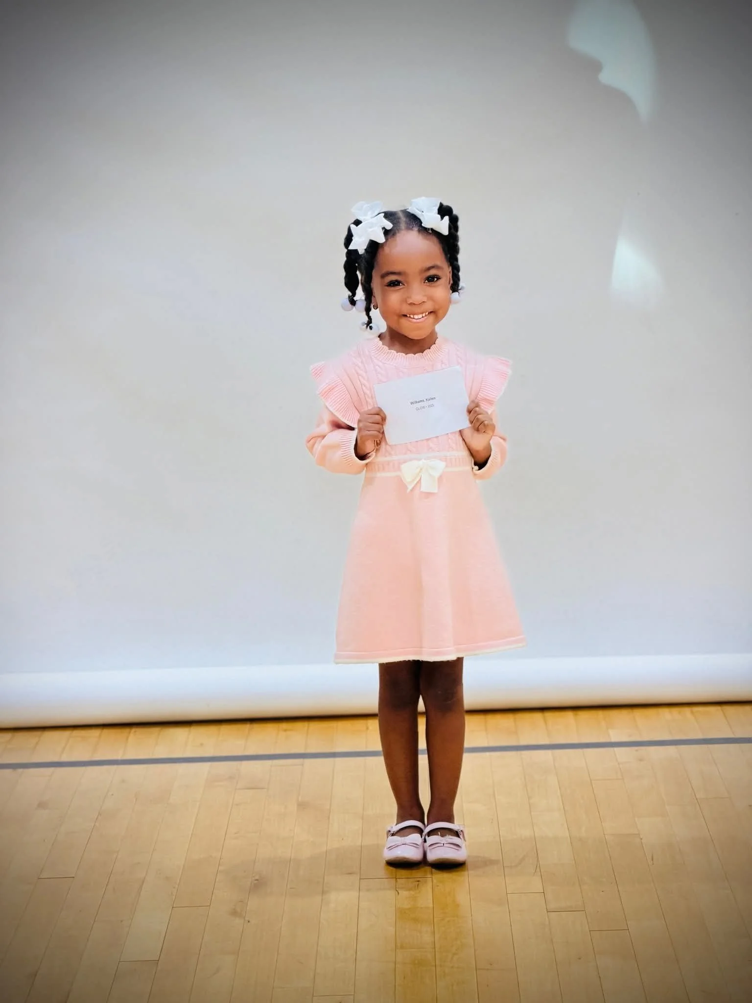 “A GLOW Mini participant smiling during a program or recognition event.
