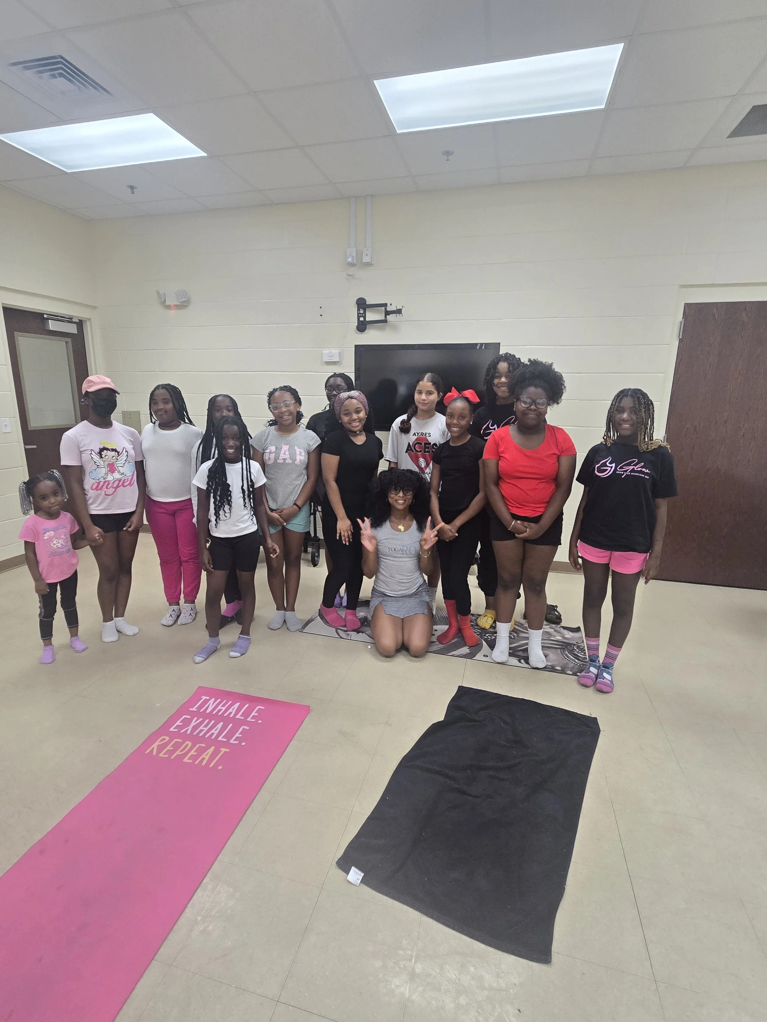 “GLOW girls and mentors participating in a group yoga and wellness session.”