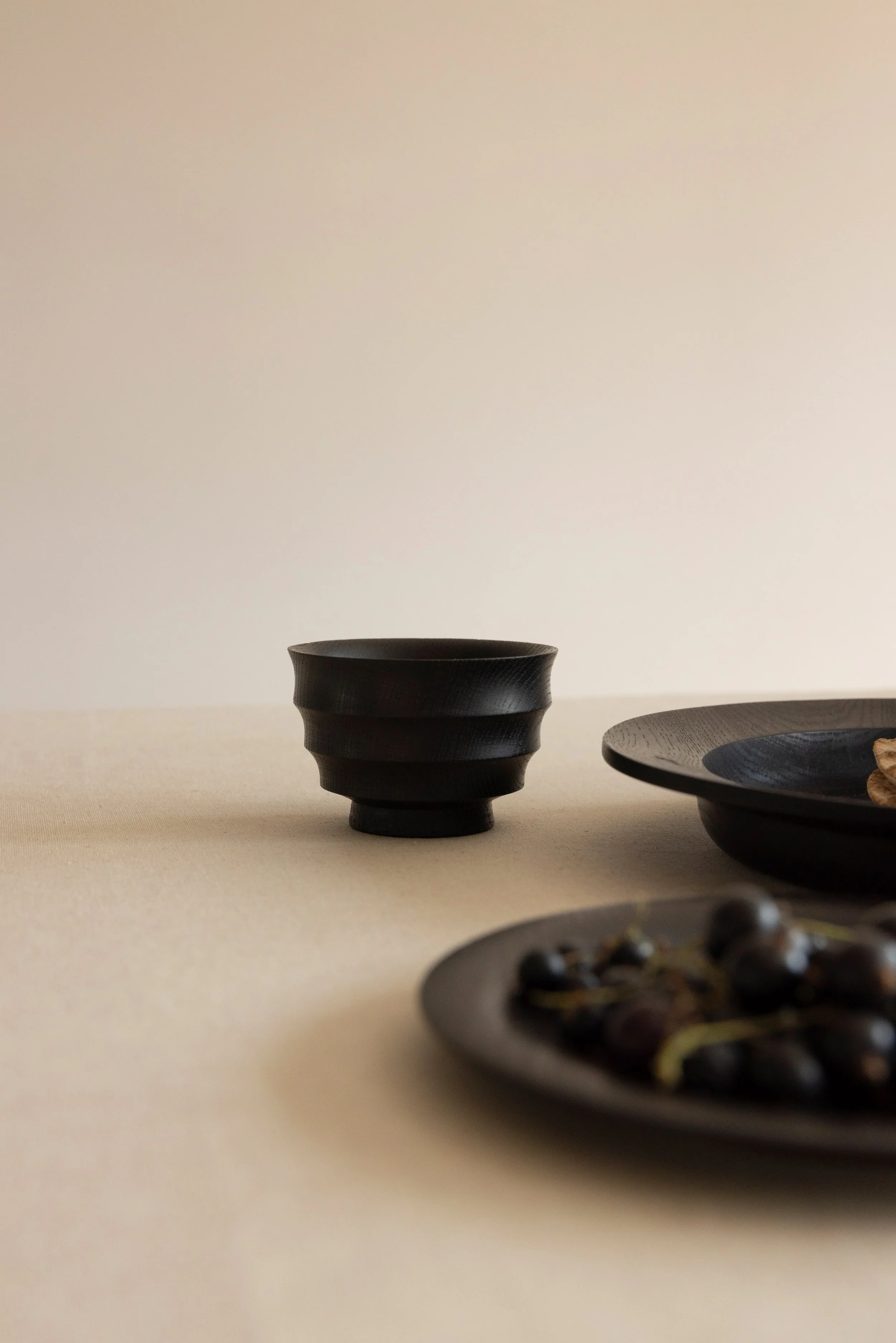 Schwarze Schalen mit japanischem Geschirr auf einem weißen Tisch, minimalistisches und elegantes Design.