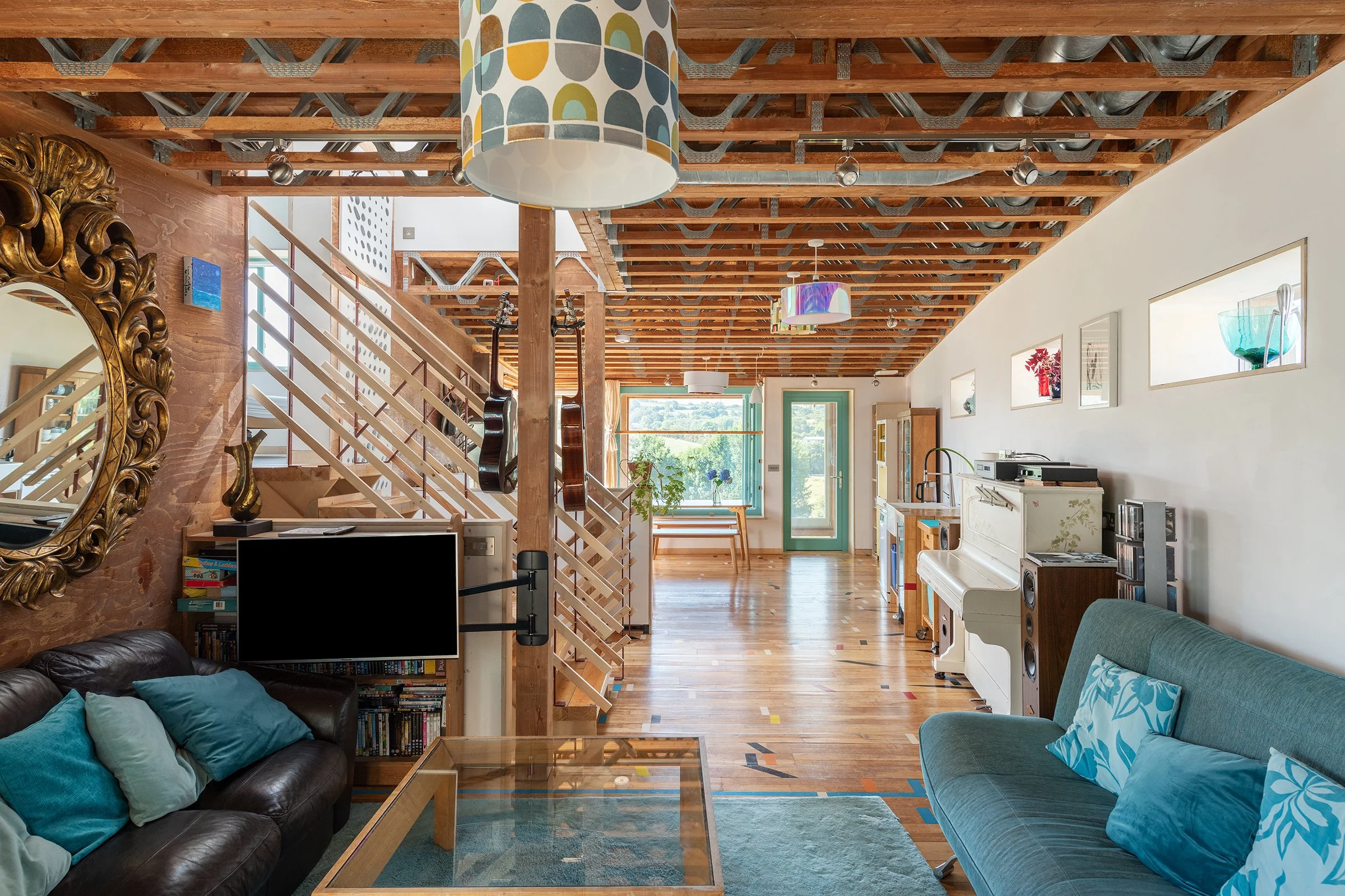 This project uses a palette of timber, glass and a planted roof to reduce its visual impact on the site. Large areas of glazing bring daylight into the living spaces, while the solar array formed an important part of the environmental strategy. The p