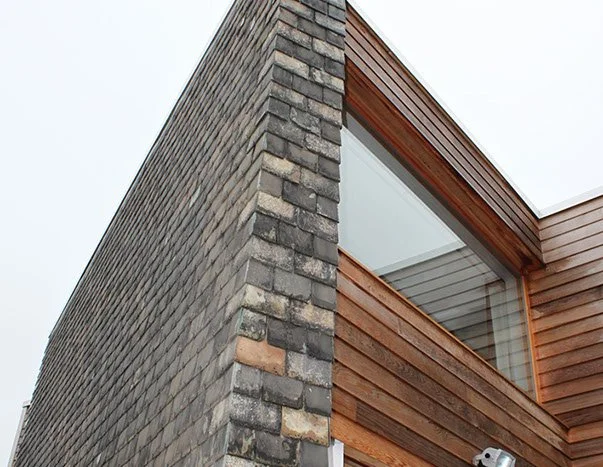 This extension uses a restrained palette of slate and timber to create a simple, contemporary addition with a strong sense of place. Carefully detailed junctions and deeply framed openings give the building definition without unnecessary fuss. The co