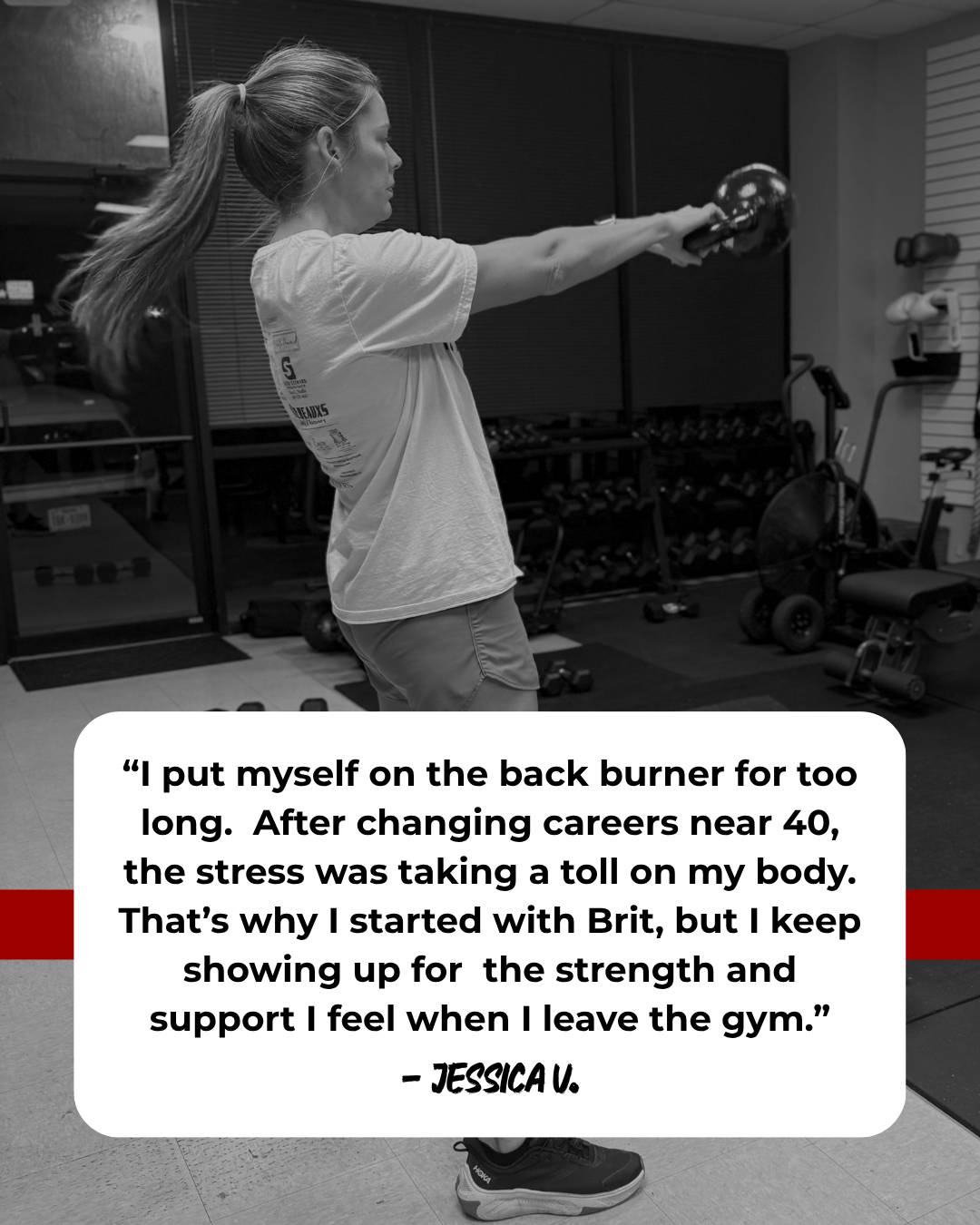 A woman with a ponytail wearing a t-shirt and shorts is performing a back exercise with a kettlebell in a gym. The gym has weight racks, a stationary bike, and other exercise equipment.