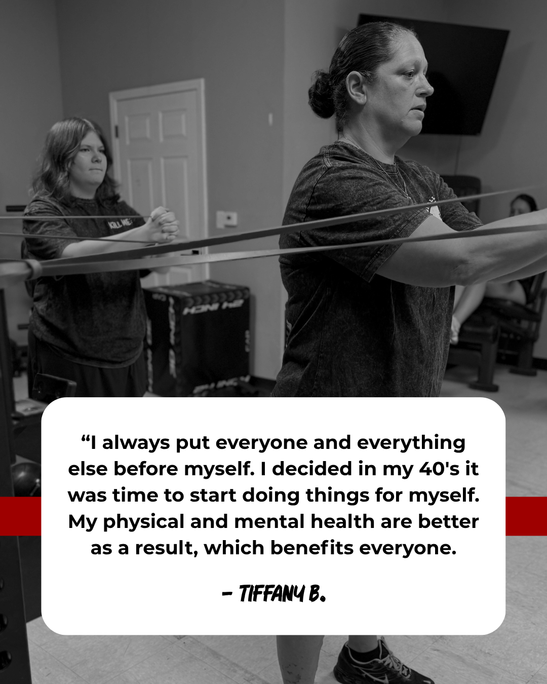 A woman and a young girl are stretching with resistance bands in a gym or fitness studio. The woman, dressed in athletic wear, is in the foreground, focused on her exercise, while the girl stands behind her, also engaged. There is a television mounte