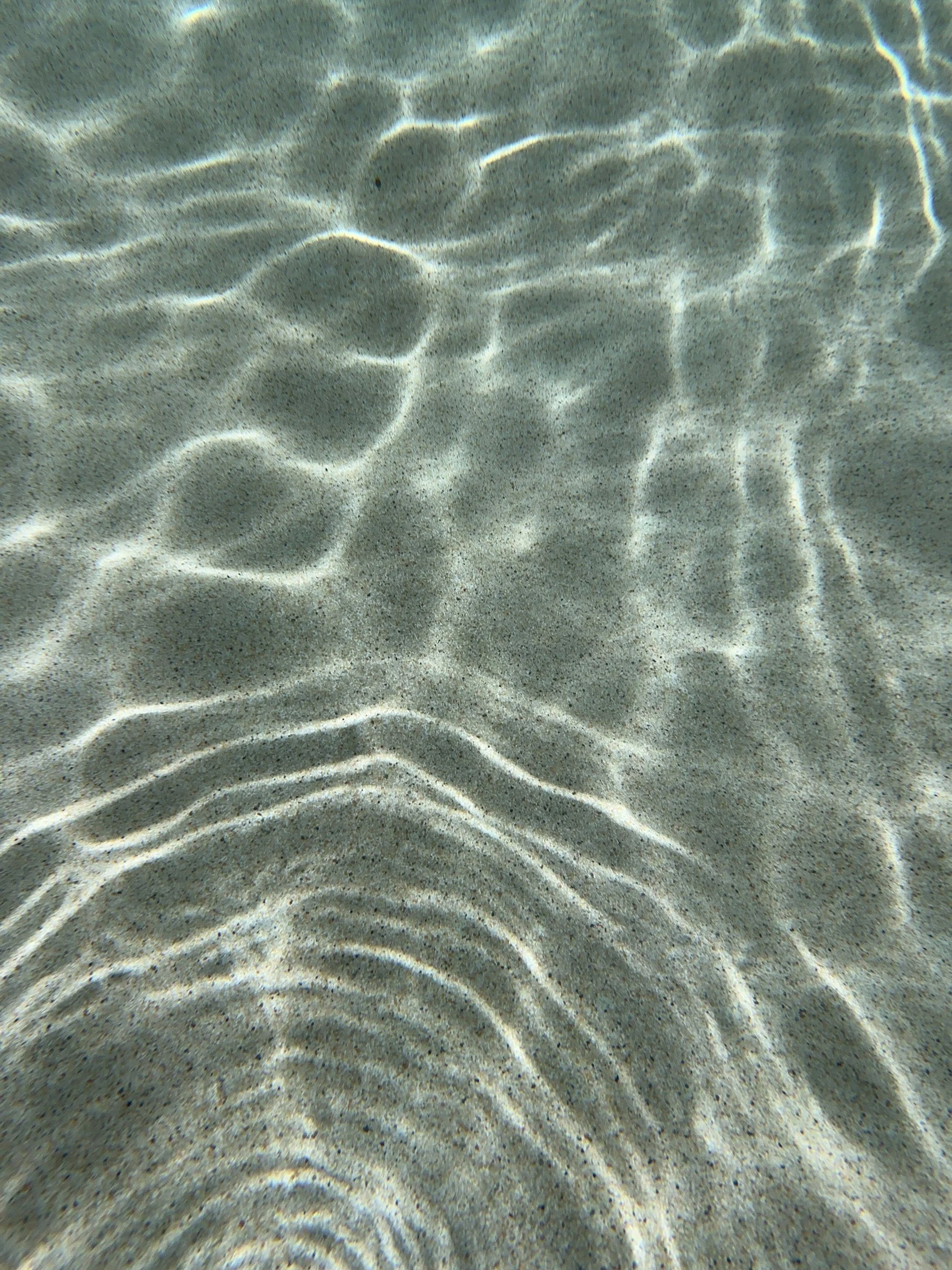 Sunlight rippling across clear shallow water