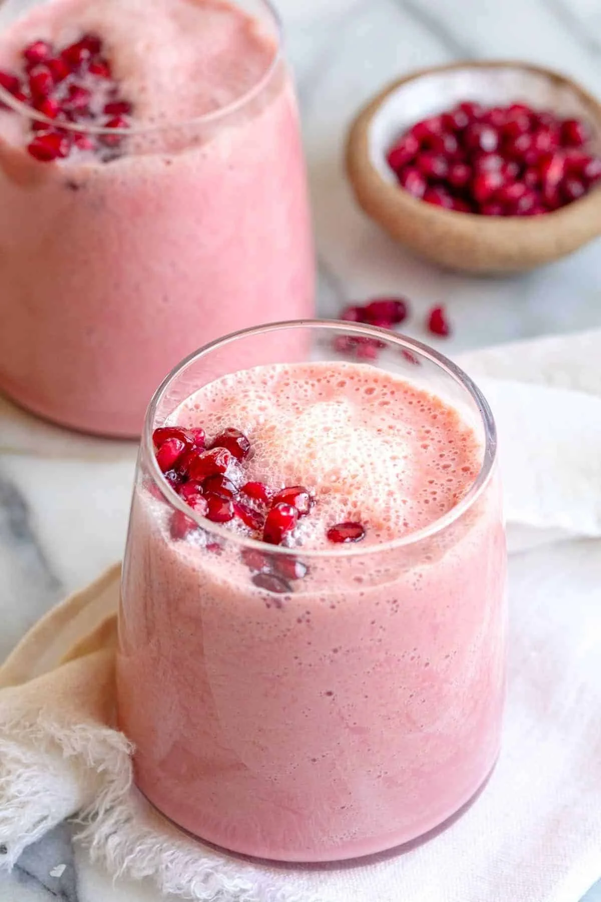 Pomegranate smoothie in glass with seeds
