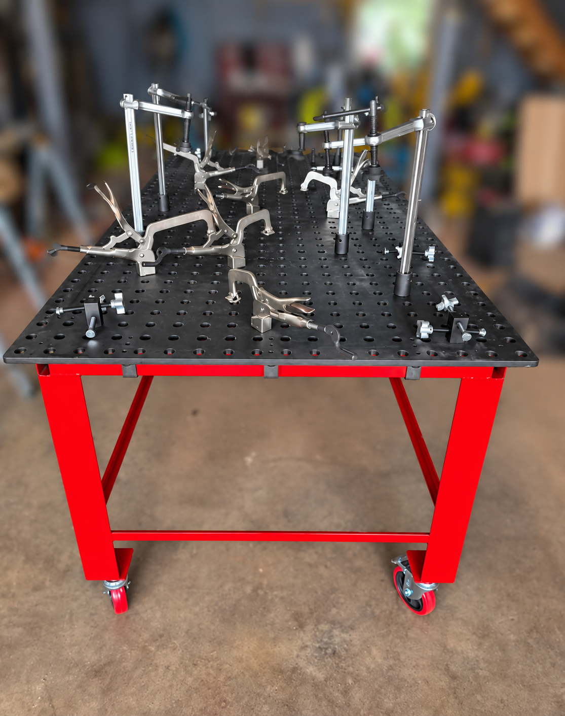 Fabrication work table with hold down clamps in a welding shop.