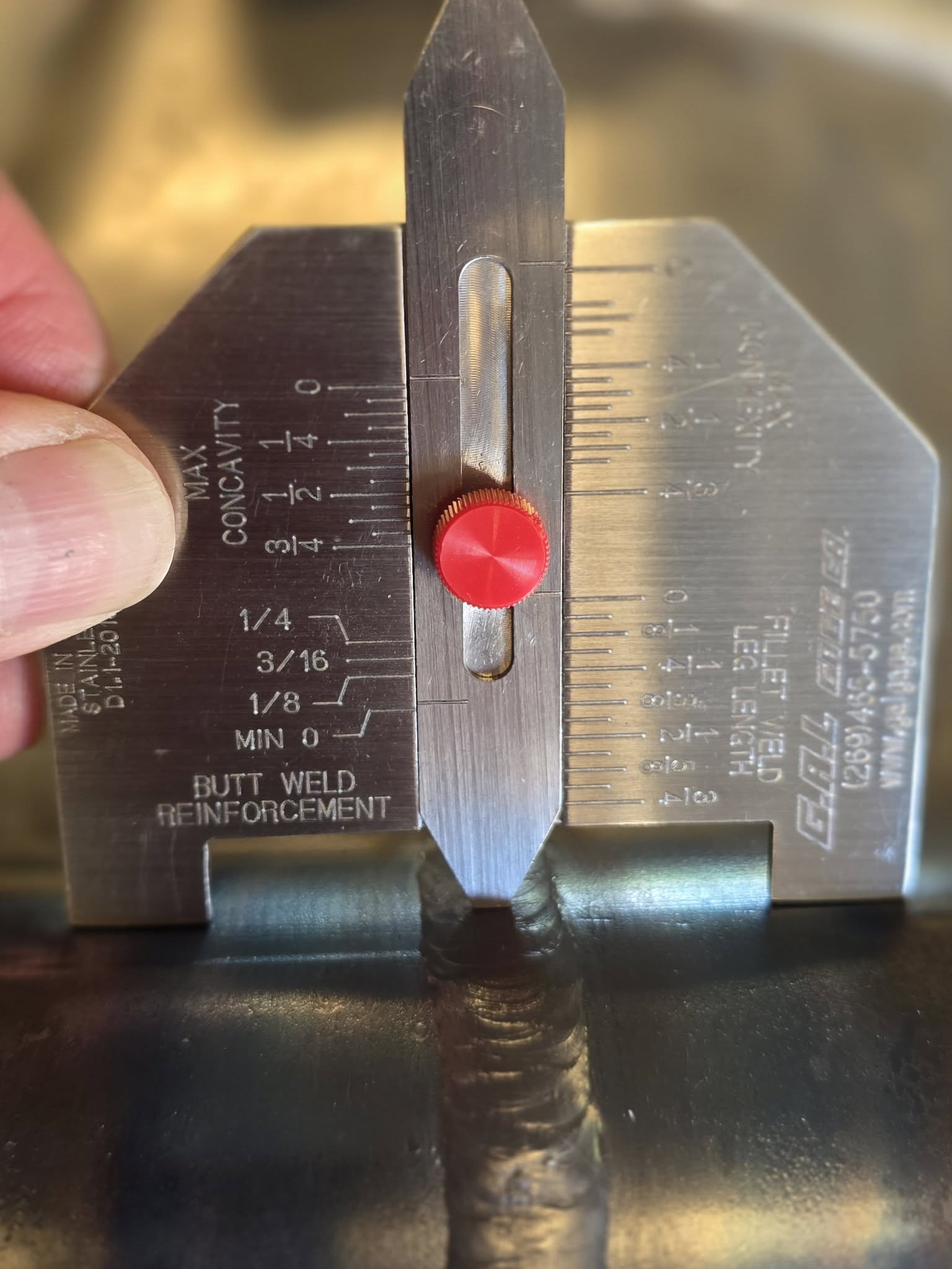 Close-up of a welding inspection gauge used to measure butt weld reinforcement.