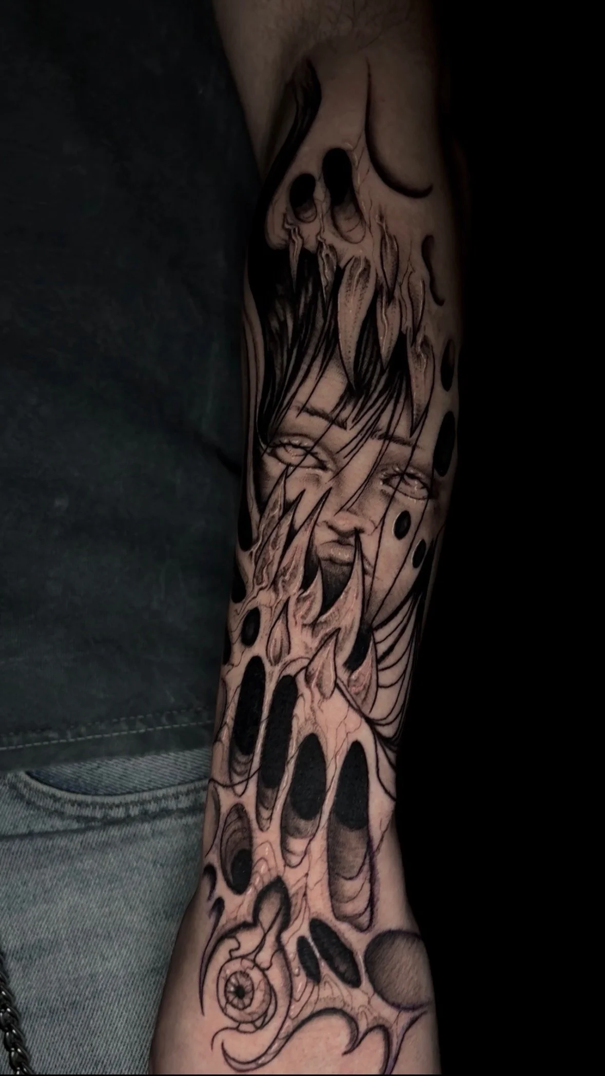 Tattoo sleeve with abstract and surreal elements, including a girl's face and organic shapes.