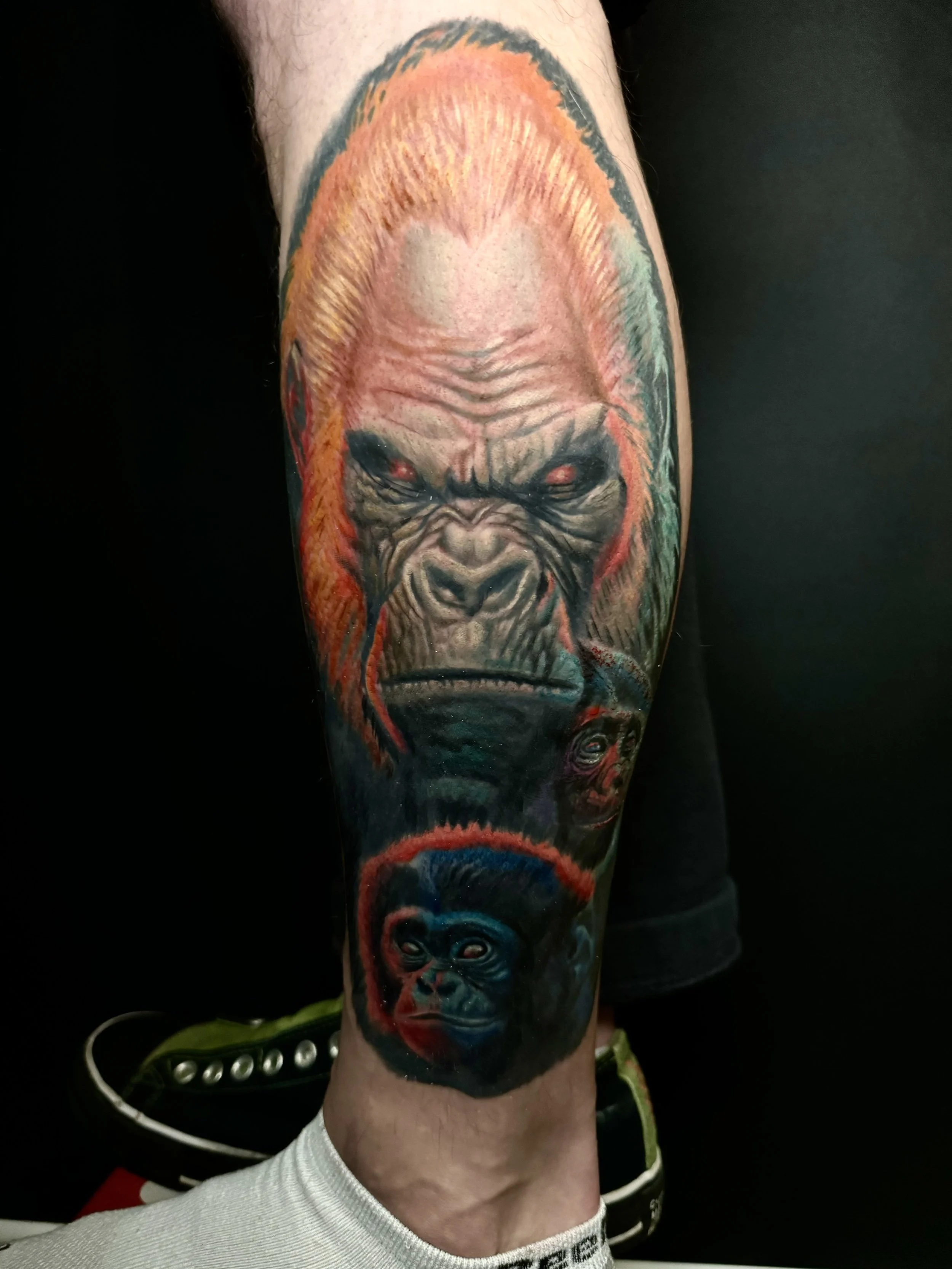 A tattoo of a chimpanzee's face on a person's arm.