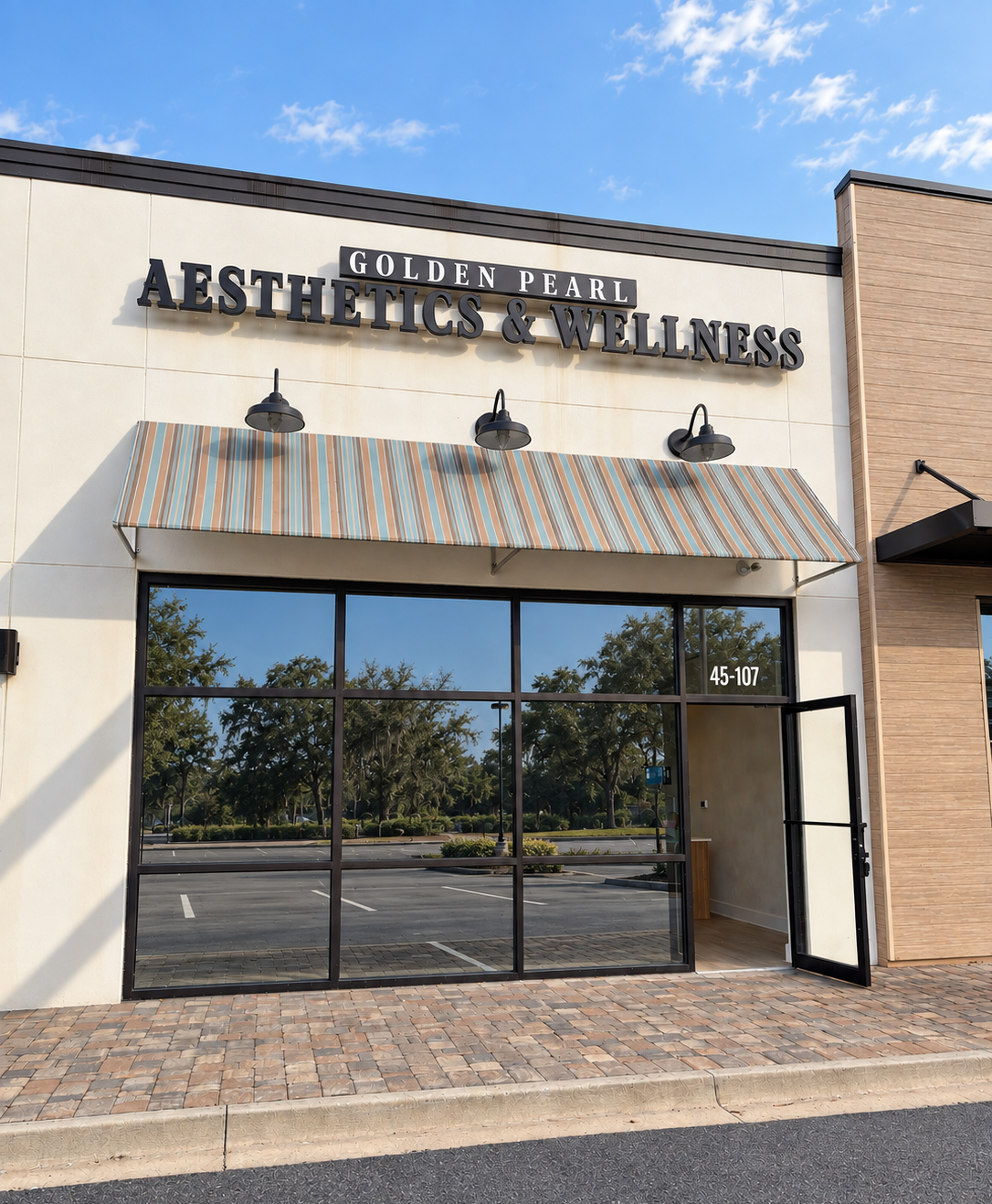 The storefront of Golden Pearl Aesthetics & Wellness with large glass windows, striped awning, and signage