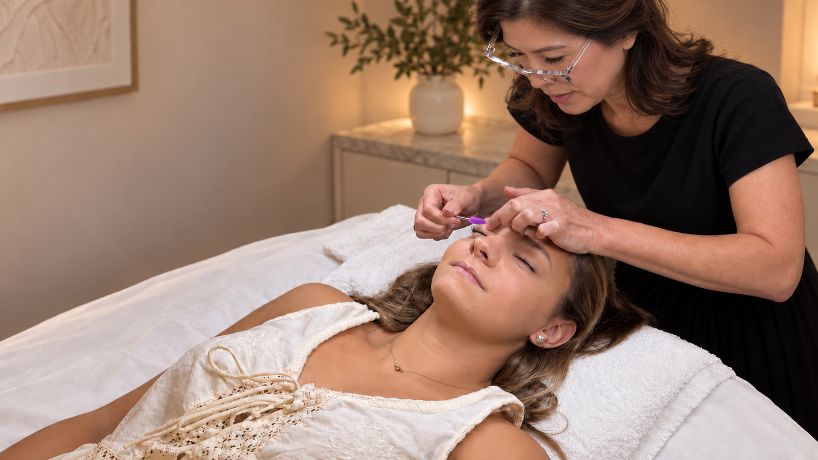 PROFESSIONAL LASH TECHNICIAN APPLYING EYELASH EXTENSION TO A CLIENT IN A COZY LASH STUDIO IN GEORGETOWN, DC