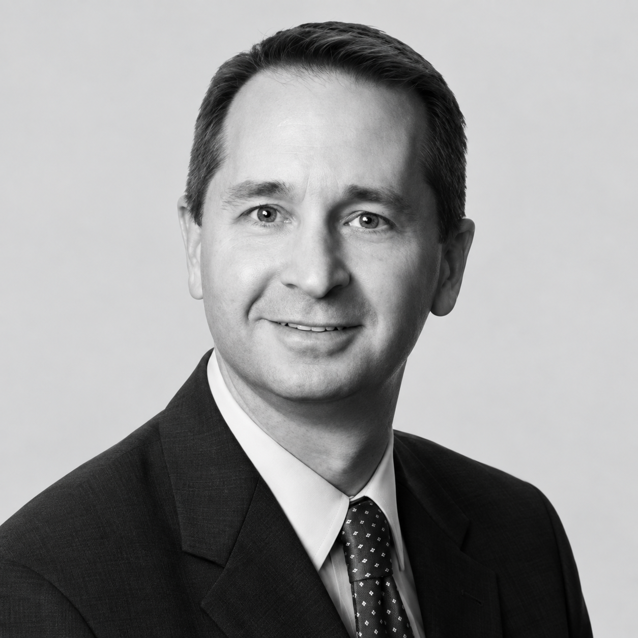 Brent Terhaar - Black and white professional headshot of a man wearing a suit and tie, smiling slightly, against a plain light background.