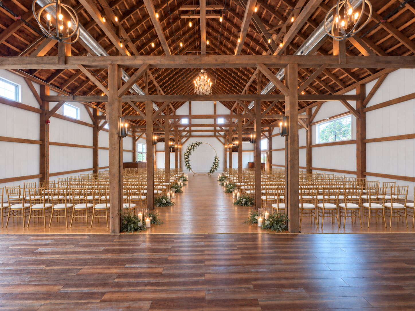 A wedding ceremony setup inside a beautiful barn in Iowa. Gold wedding chairs for rent in Iowa. 