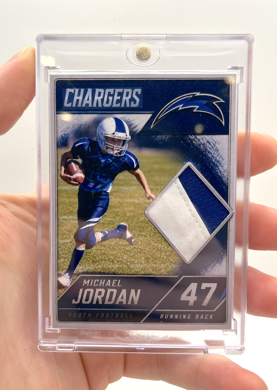 Sports trading card of Michael Jordan, a youth football player in a blue uniform with the number 47, holding a football, with team logo and fabric patch on a black and blue background.