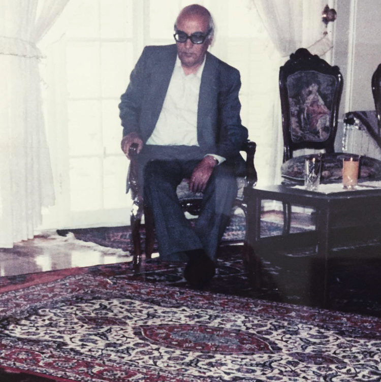 Family archive photo of an earlier generation seated among Persian carpets