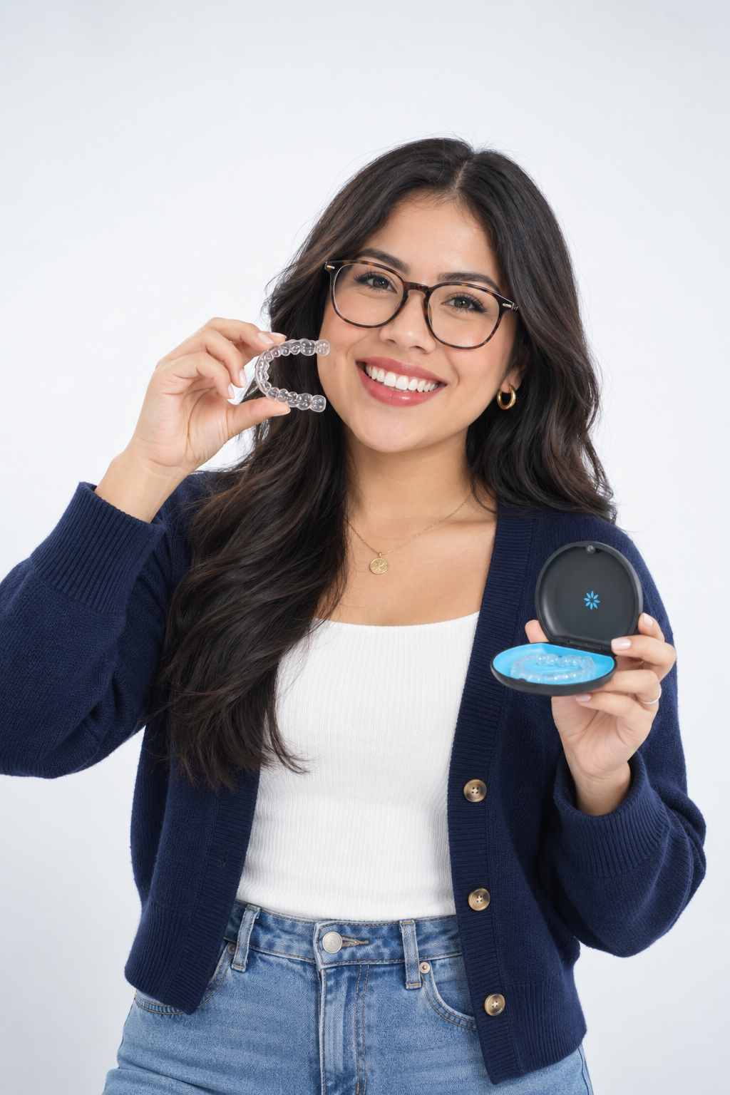 Woman holding a clear Invisalign aligner and its carrying case.