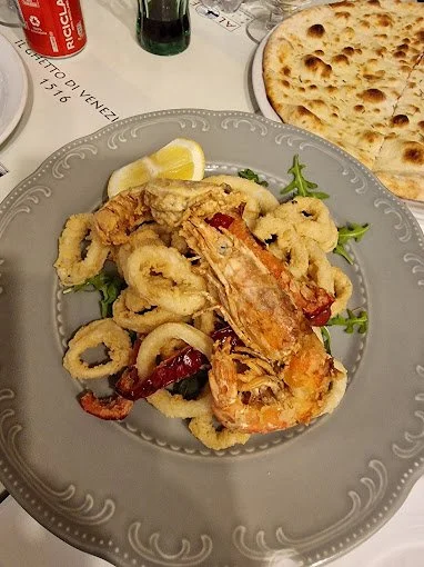 Frittura di calamari con gamberi e limone, accompagnata da pane e bevande.