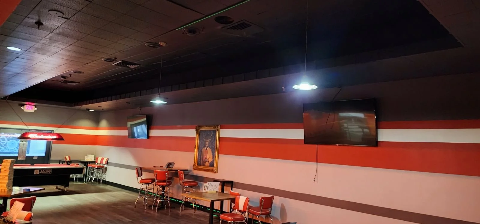 An empty entertainment room with a pool table and TV inside a recreational space.