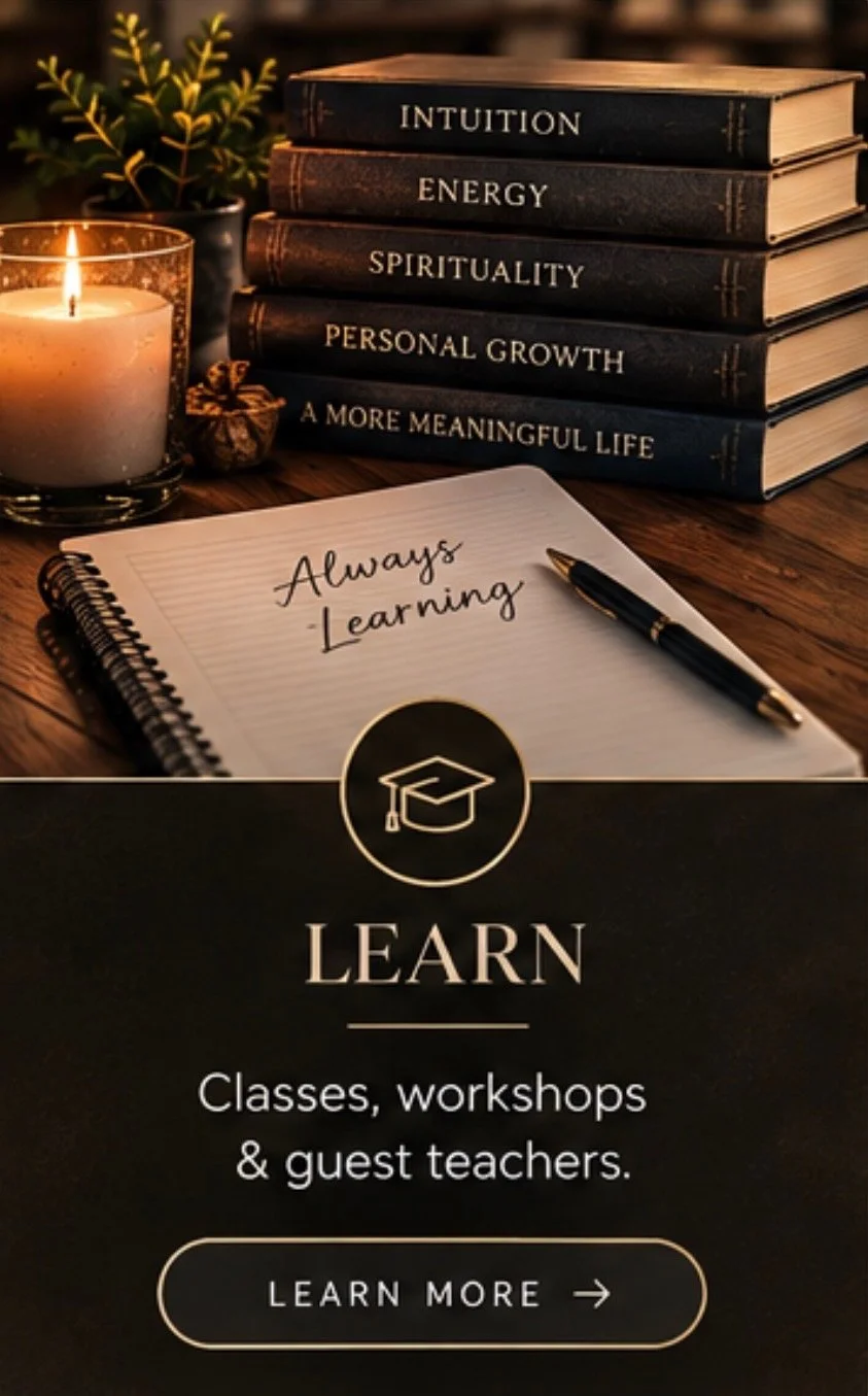 Stacks of books with titles such as 'Intuition,' 'Energy,' 'Spirituality,' 'Personal Growth,' and 'A More Meaningful Life,' a lit candle, a small plant, a notebook with 'Always Learning' written on it, and a pen, all on a wooden table, with a dark background and an overlay with a graduation cap icon and the word 'Learn' promoting classes, workshops, and guest teachers.