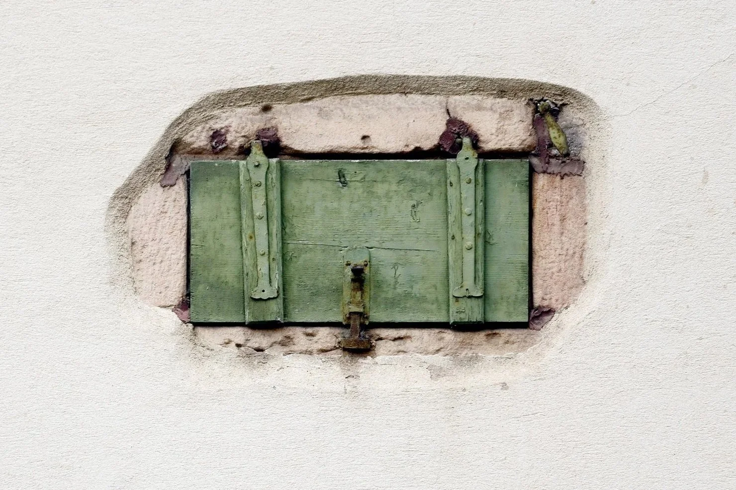 Green wooden shutters in a weathered stone wall, Experience
