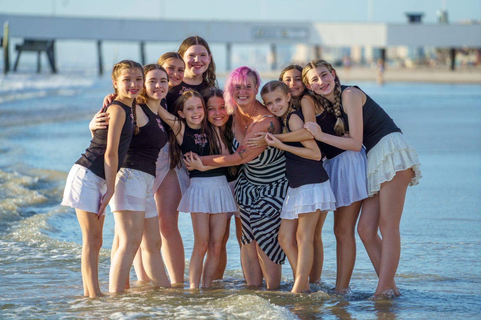 TTP dancers and teacher sharing a beach hug