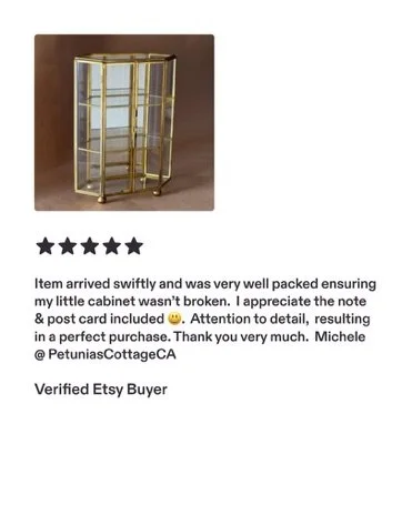 A small gold and glass display cabinet with multiple shelves.