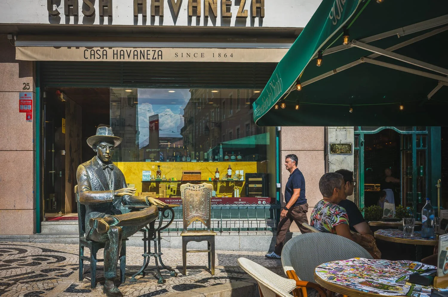 Bronze statue of Fernando Pessoa seated at a café table outside the Casa Havaneza in Chiado