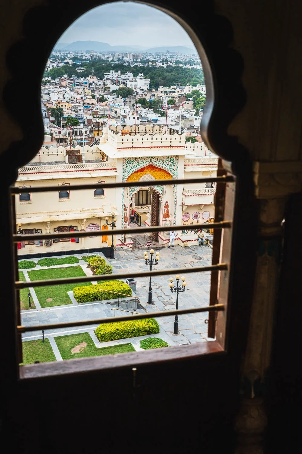 A palace courtyard and the city beyond, seen through an arched window