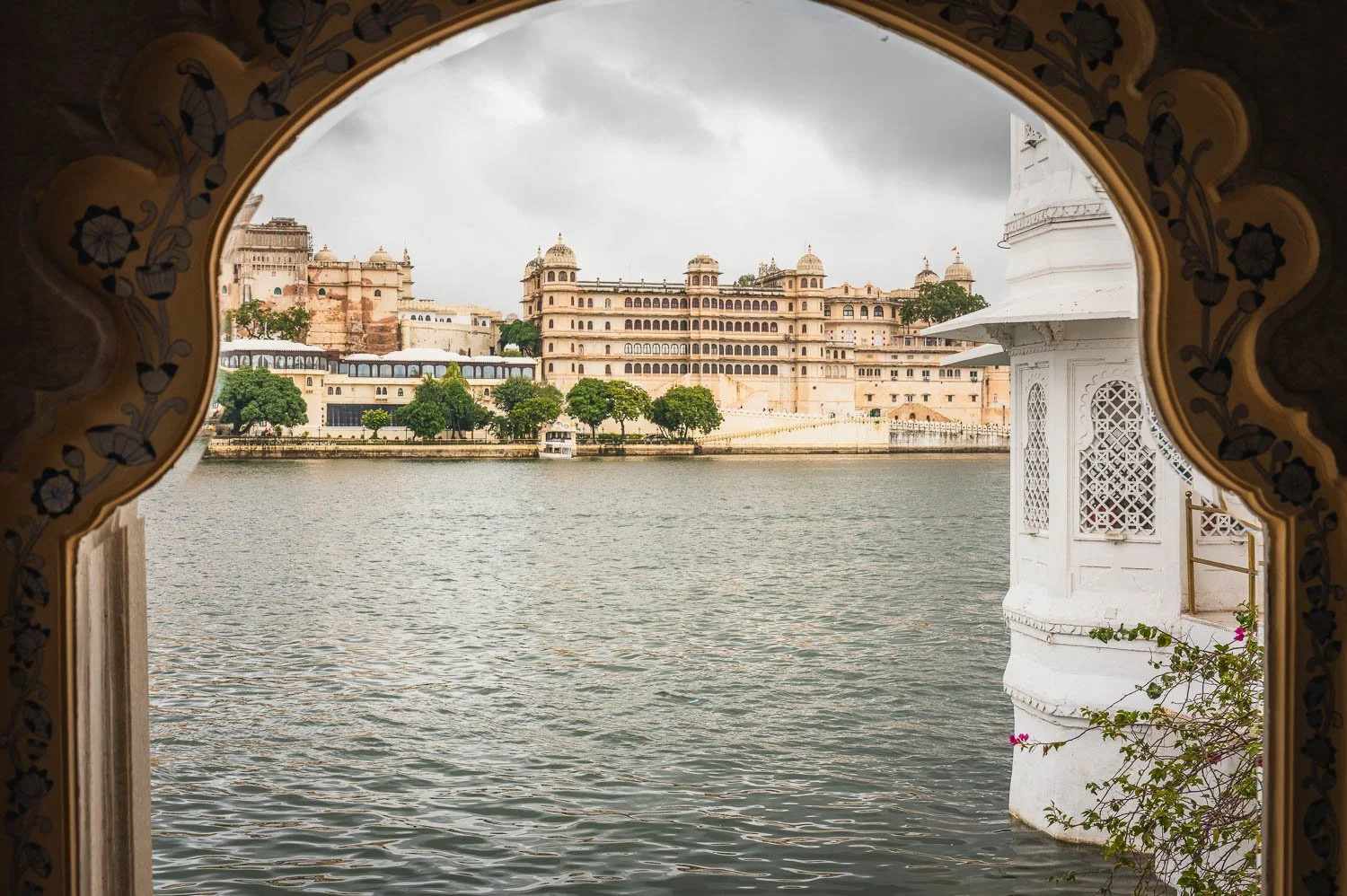 The City Palace across Lake Pichola, framed by a scalloped arch