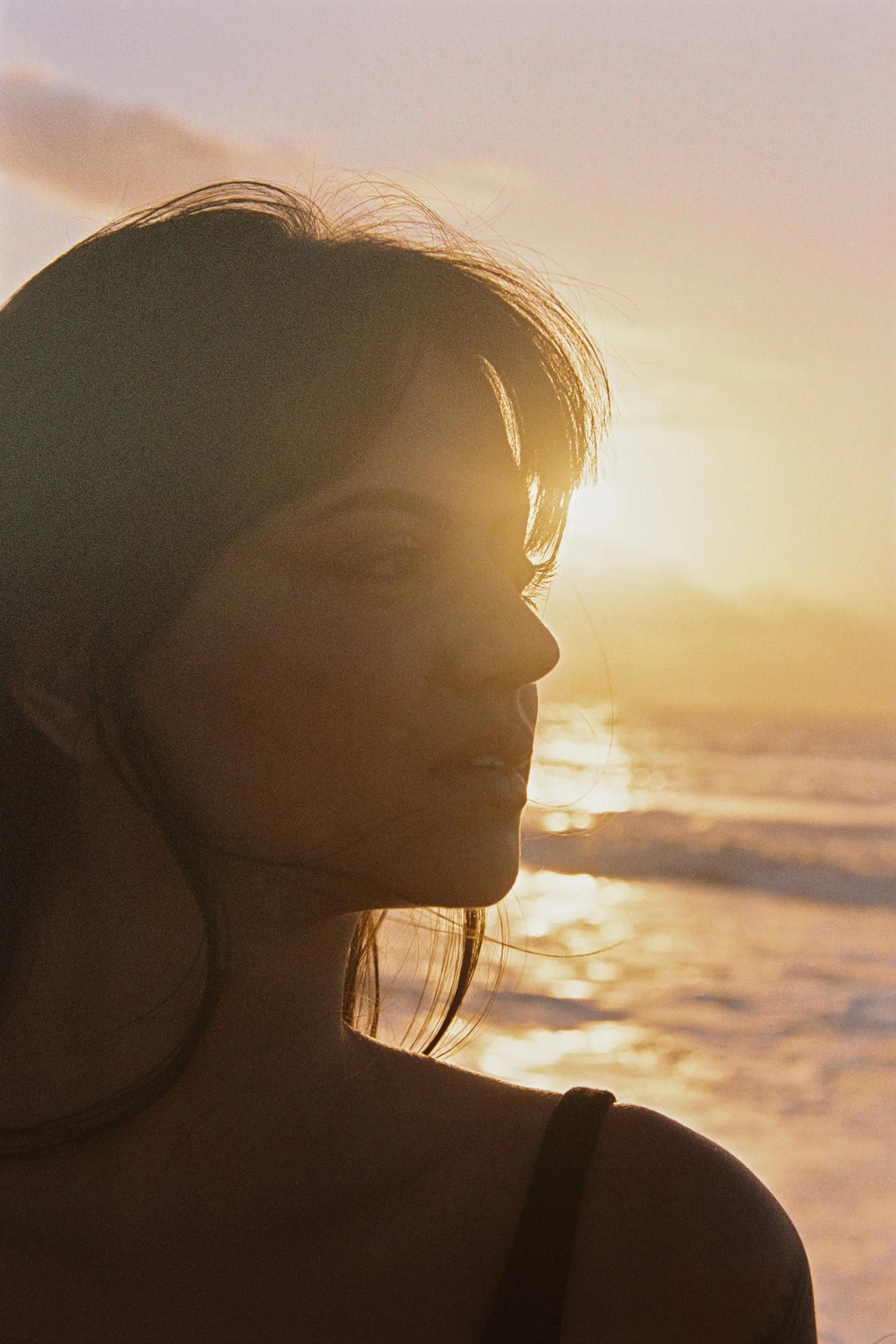 Backlit profile with the sun catching loose strands of hair, 35mm film