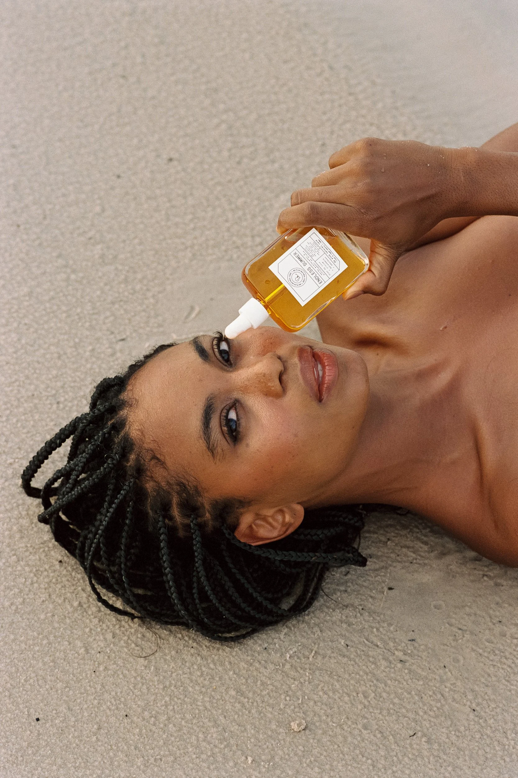 Suzana Massena on sand with Be Plus Endless Summer tanning oil, 35mm film