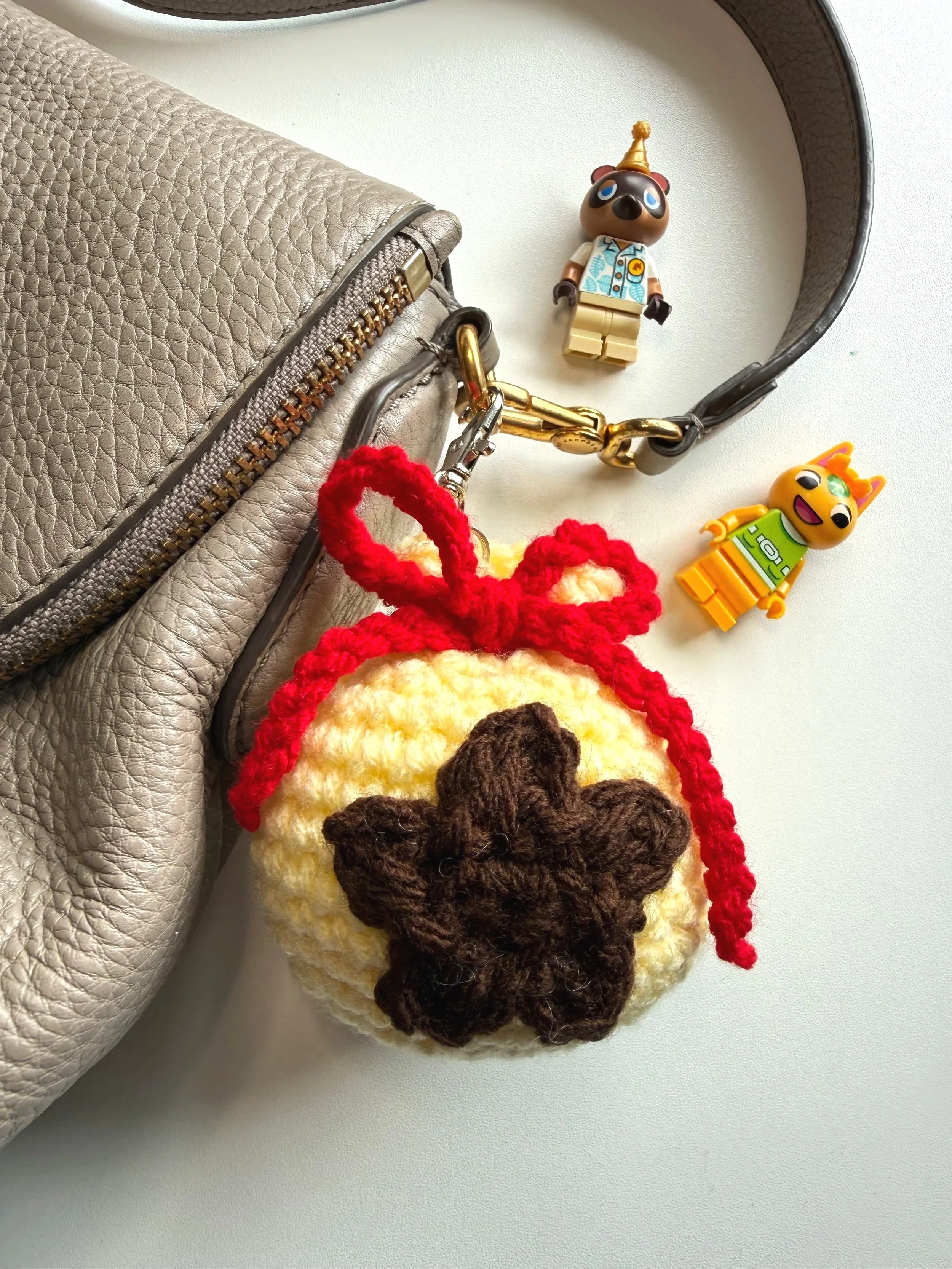 crochet animal crossing money bag with a tan purse