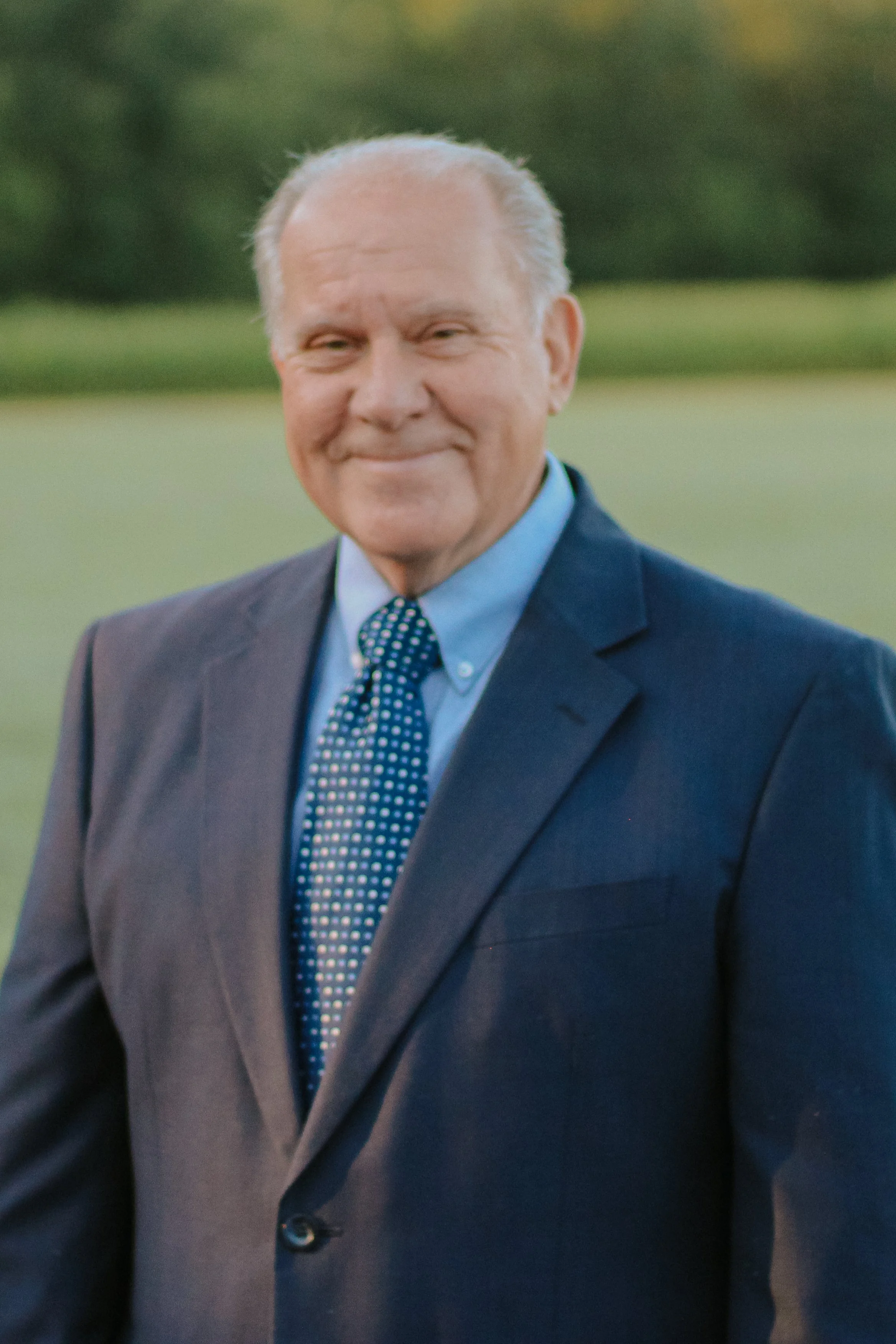 Portrait of an older man in a suit and patterned tie outdoors