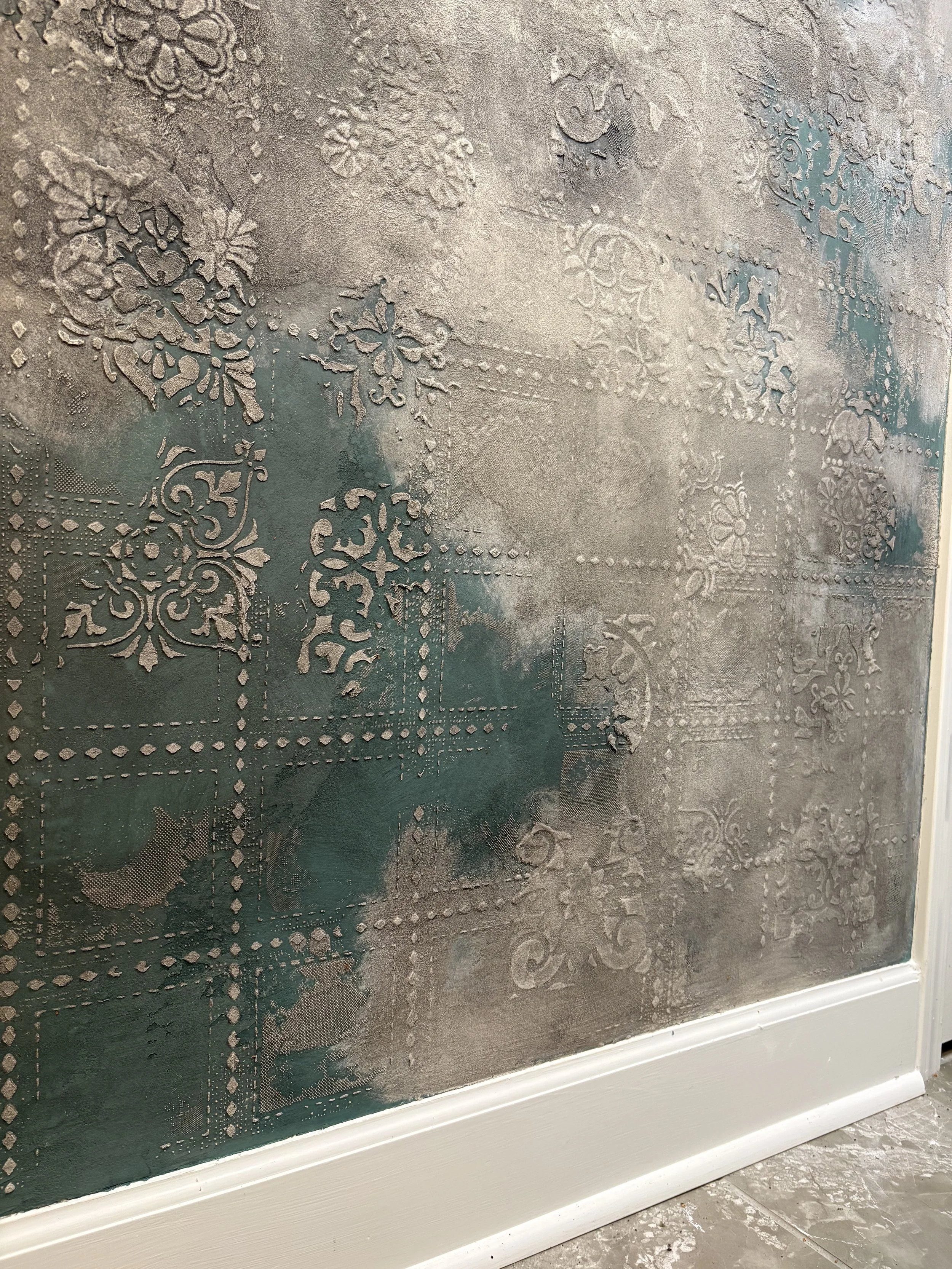 Custom layered decorative plaster with raised pattern and metallic texture.