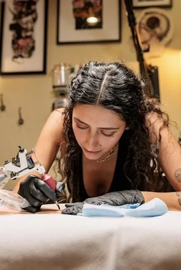 Tattoo artist working on a tattoo in a tattoo studio.