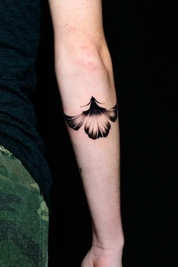 Tattoo of a butterfly on a person's forearm.