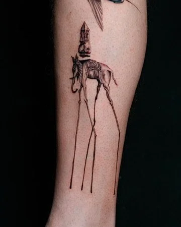 Tattoo of a giraffe with a lion's head on its back on a person's forearm.
