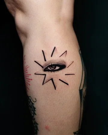 Tattoo of an eye with radiating lines on a person's waist.